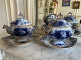 a blue and white teapot and saucer on a marble table
