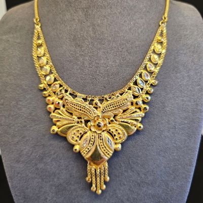 un collier en or exposé dans une vitrine
