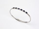 un gros plan d'une bague en or blanc sertie de saphirs bleus