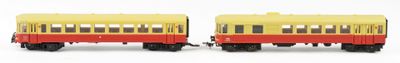 two toy trains sitting side by side on a white surface