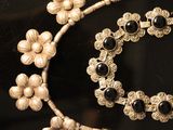 a close up of a necklace and bracelet on a table