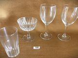 four empty wine glasses sitting on a table next to a price tag
