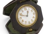 une petite horloge en bois dans une boîte posée sur une surface blanche