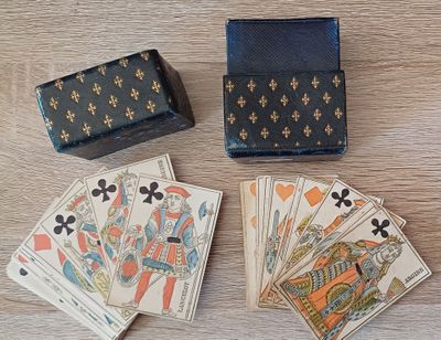 plusieurs cartes à jouer et une boîte posées sur une table en bois