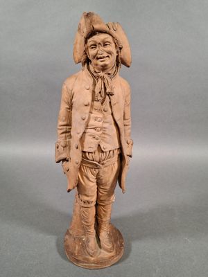 statue en bois représentant un homme portant un chapeau et une veste