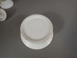 a white plate sitting on a table next to a cup and saucer