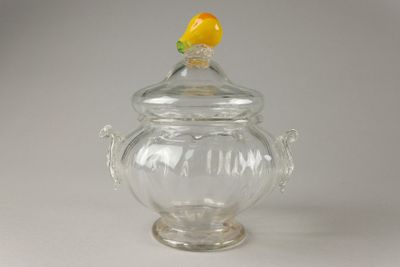 un bocal en verre sur lequel est posé un citron