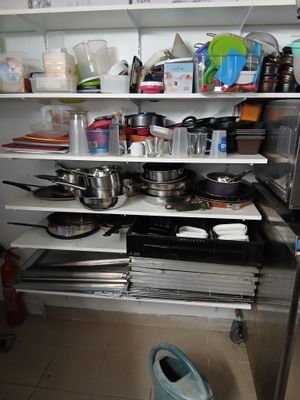 de nombreuses casseroles et poêles sur les étagères de la cuisine