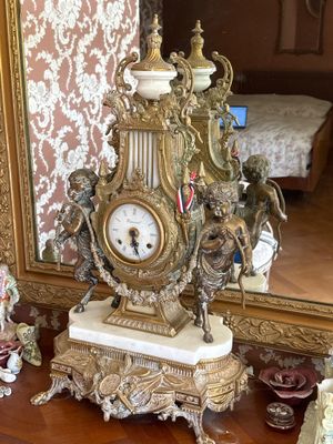 une horloge posée sur une table devant un miroir