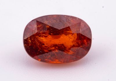 un saphir orange de forme ovale sur un fond blanc