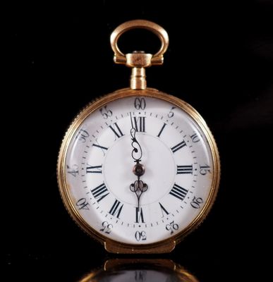 a gold pocket watch with roman numerals on the face