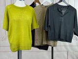 three sweaters hanging on a clothes rack in a room