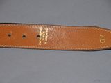 a close up of a brown leather belt on a gray surface