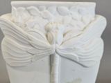 a white vase with a dragonfly on it on a table