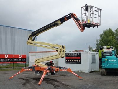 a man standing on a cherry picker in the middle of a parking lot