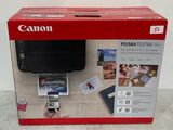 Imprimante Canon Pixma 3525i dans une boîte, avec une main tenant un téléphone