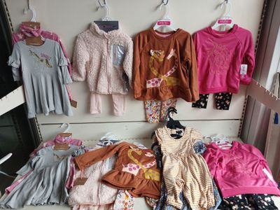 beaucoup de vêtements suspendus à une étagère dans un magasin