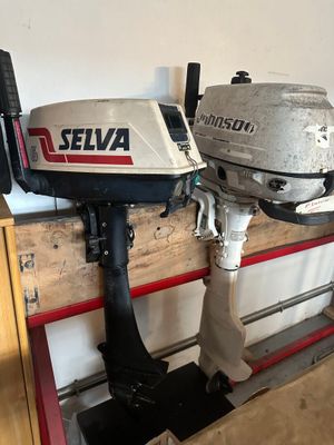 deux moteurs hors-bord posés sur une palette dans un garage