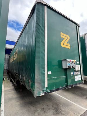 un semi-remorque vert garé sur un parking