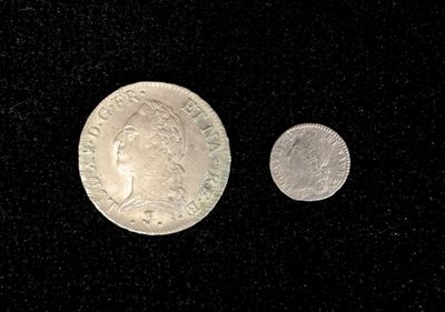 an image of a silver coin and a silver coin on a black surface