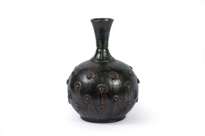 un vase noir posé sur une surface blanche, avec un fond blanc
