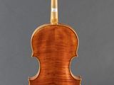 a violin with a wooden back and bow on a stand