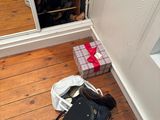 un sac noir posé par terre à côté d'un meuble à chaussures