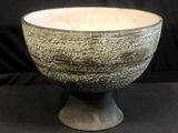 an image of a bowl on a pedestal on a black background