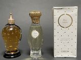 two bottles of perfume sitting next to each other on a table