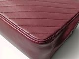 a close up of a red purse on a white surface