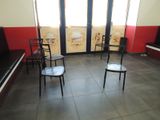 four chairs in a room with a piano in front of them