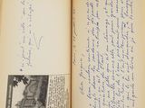 an open book with a handwritten page on it sitting on a table