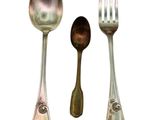 three spoons and a fork sitting next to each other