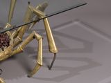 a glass table with a gold spider on top of it