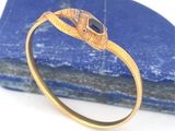 une image représentant une bague en or ornée d'une pierre noire au centre