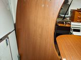 un bureau en bois et un réfrigérateur dans un coin de la pièce