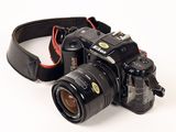 a black camera with a red strap on a white background