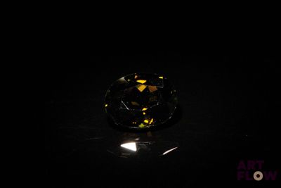 gros plan d'un diamant jaune sur une surface noire