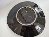 a black plate with a gold ring on top of it