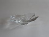 un petit bol en verre posé sur une table, avec une cuillère