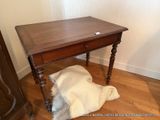 une petite table en bois posée sur un tapis en fourrure posé à même le sol