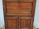 une vieille armoire en bois posée sur un bloc de bois
