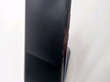 the back of a black cell phone sitting on top of a white table