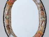 a close up of a mirror on a wall with shells on it