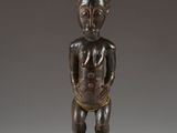 an image of a wooden statue of a man holding a baby