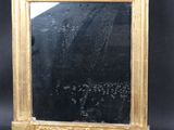 an image of a gold framed mirror sitting on top of a black table