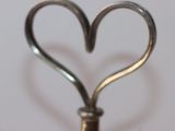 a heart shaped metal object on a white surface