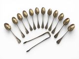 six spoons and a spoon rest in a circle on a white surface