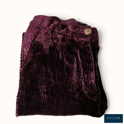 Le pull violet est posé sur une surface blanche.