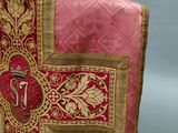 the back of a red and gold vest with a cross on it